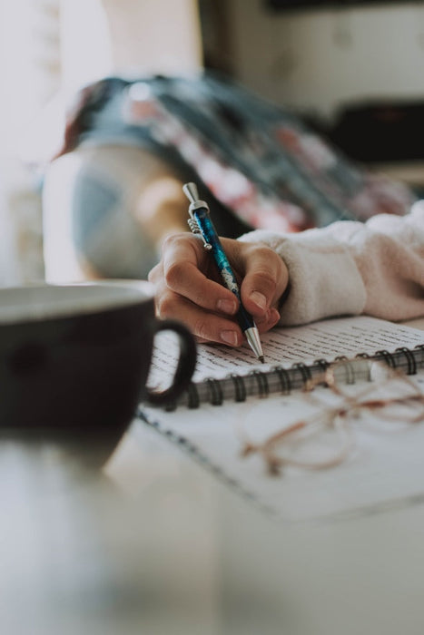 a woman writing something on her journal